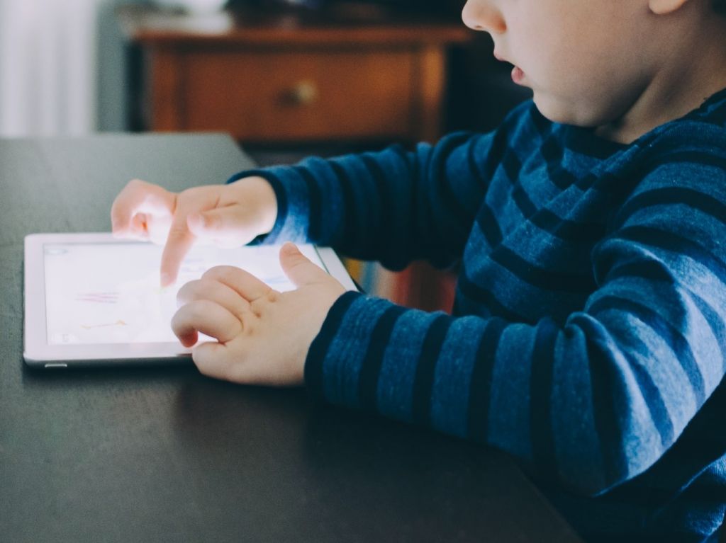 طفل يلعب بجهاز لوحي، كيف تحميه من أضرار الألعاب الإلكترونية؟